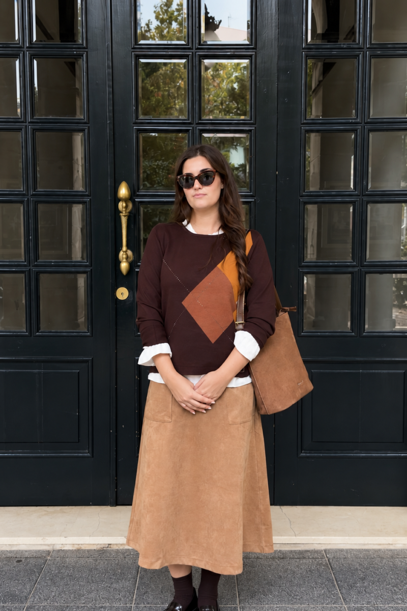 Mujer con jersey de rombos tierra y falda midi camel Amichi